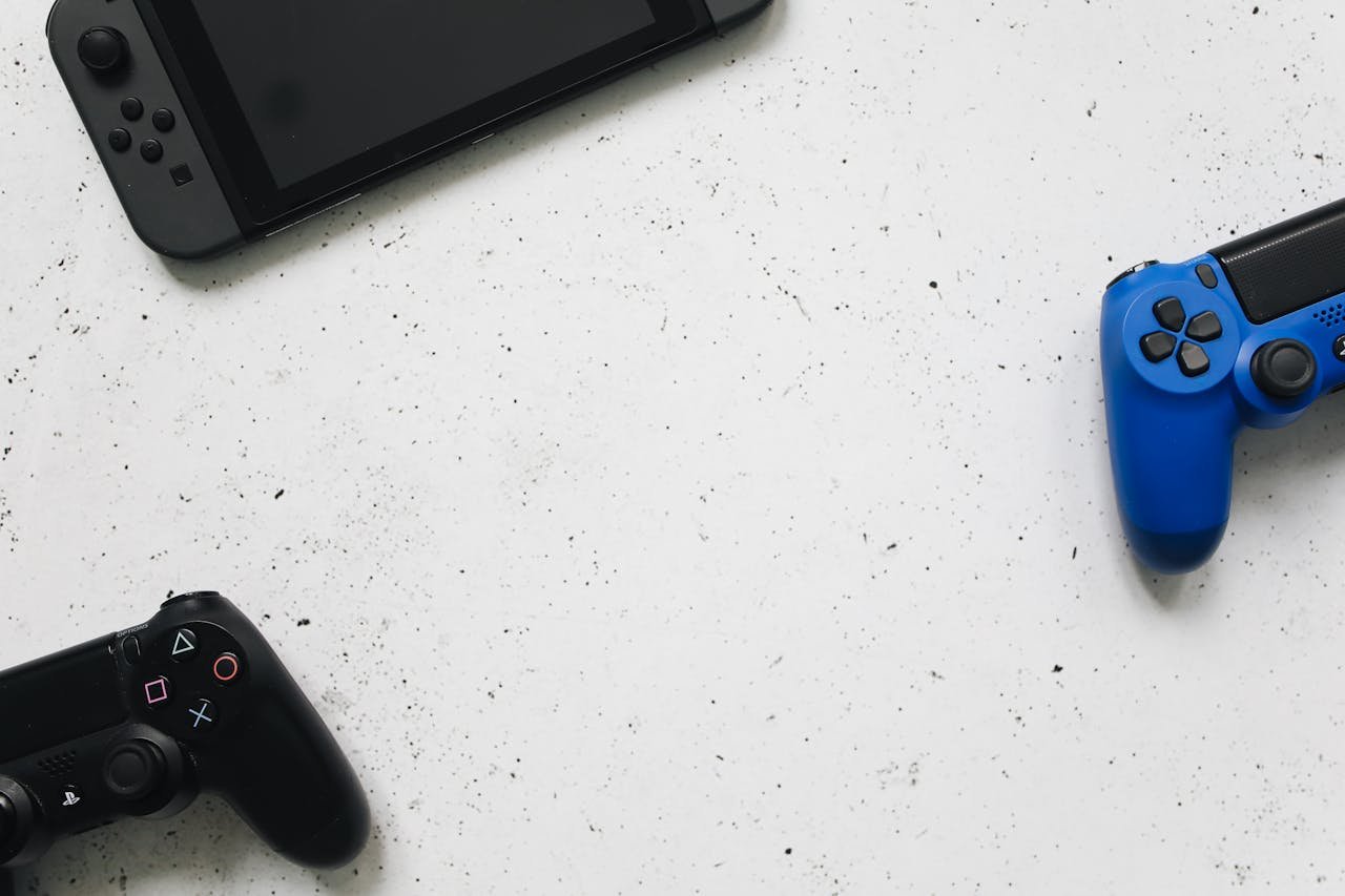 A flat lay of gaming consoles and controllers on a white surface, ideal for tech enthusiasts.